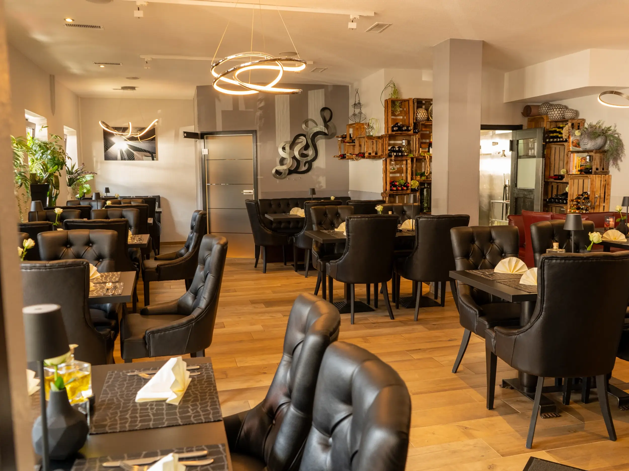 Ein Restaurant mit gemütlicher Einrichtung und Weinkisten an der Wand.